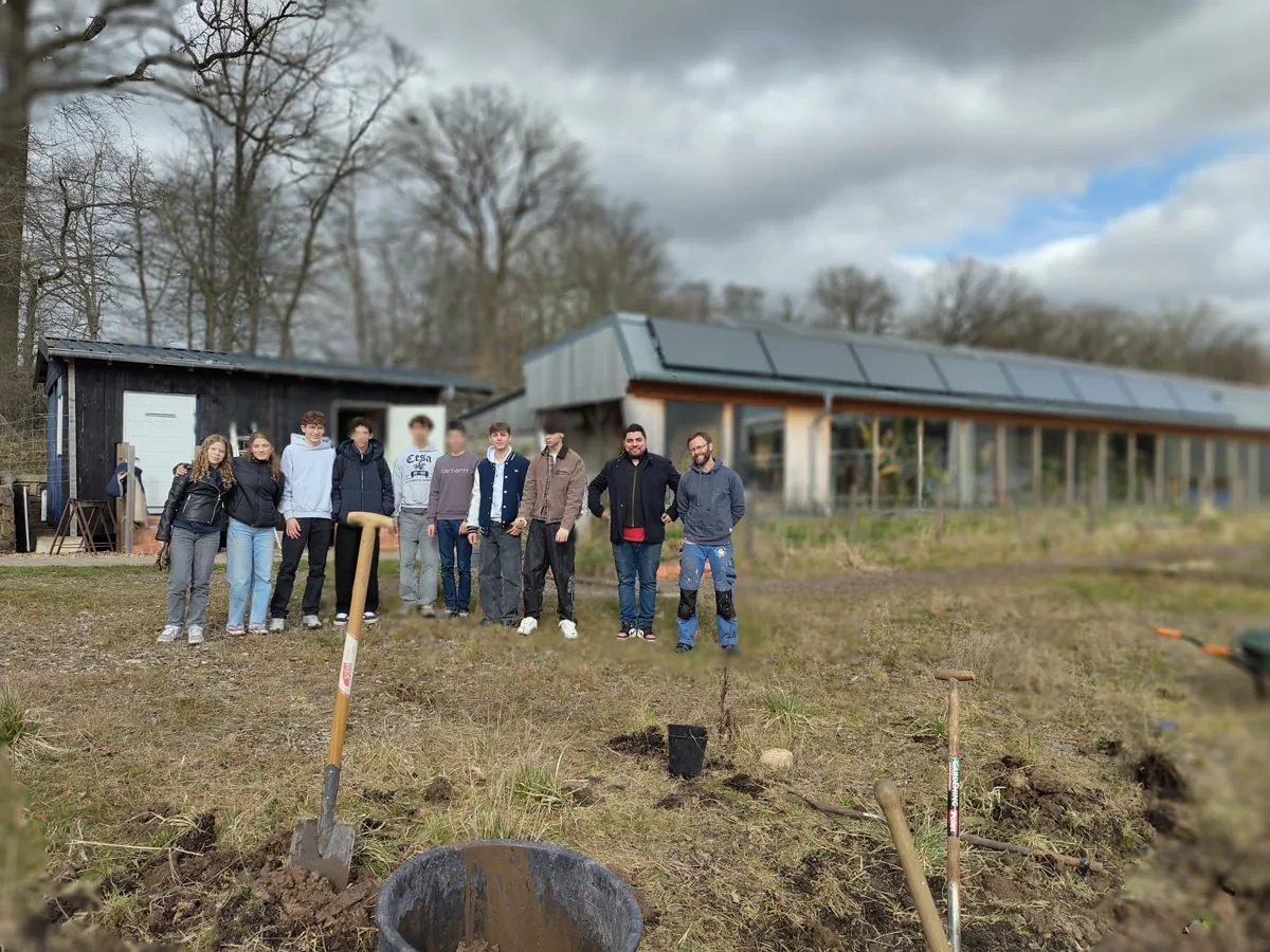 A group in front of the Äerdschëff building during a gardening workshop